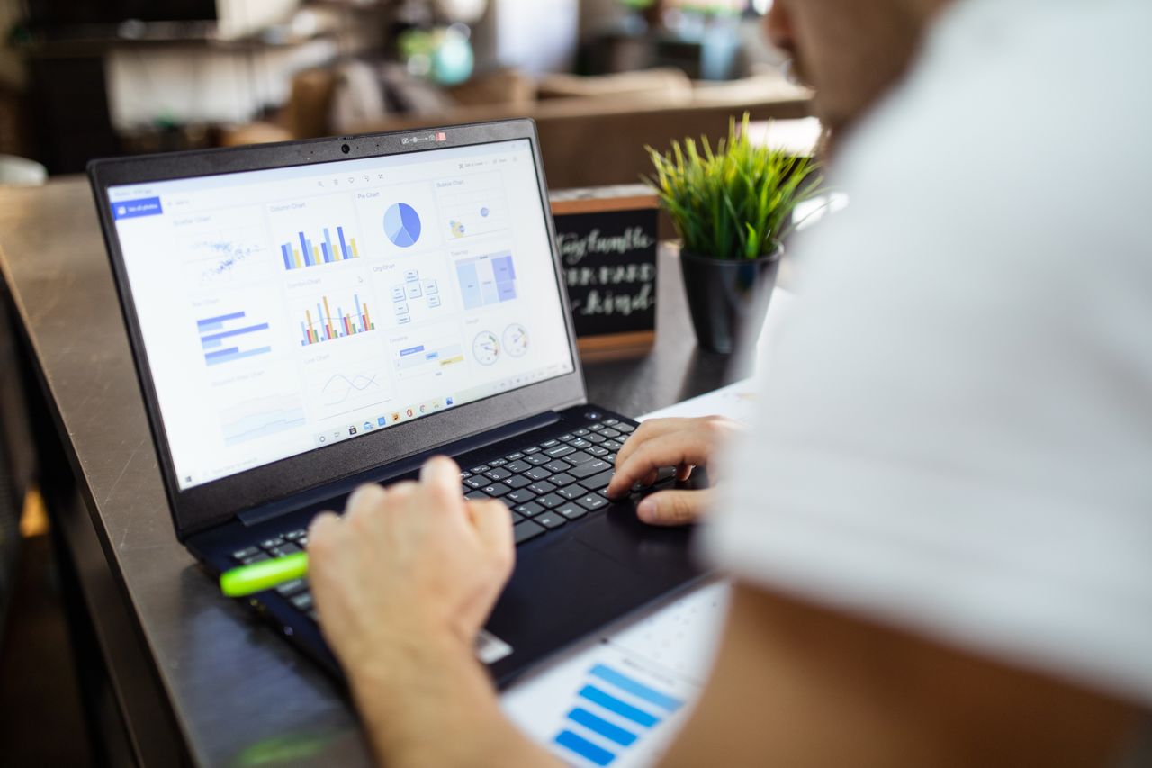 The Art of Drawing Readers In: Your attractive post title goes here Focused business analysis with charts and graphs on a laptop in a modern office setting.